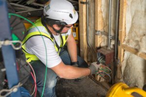 An electrician from Encore Electrical working on the re-wiring of the historical restoration of the West Yellowstone Airport.