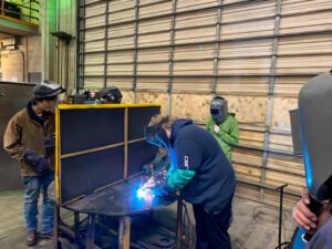 Build Montana students demonstrating welding skills typically used in a diesel mechanic service facility.